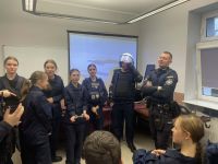 Uczniowie wraz z policjantami na komisariacie.