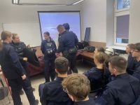 Uczniowie wraz z policjantami na komisariacie.