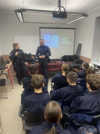 Uczniowie wraz z policjantami na komisariacie.