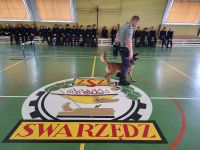 Funkcjonariusz z psem i klasy mundurowe na sali gimnastycznej