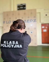 Uczeń trzyma broń i strzela do celu