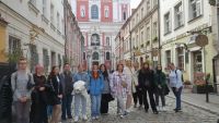Uczniowie stoją na tle Bazyliki przy Starym Rynku w Poznaniu