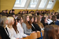 Społeczność uczniowska siedząca podczas uroczystości.